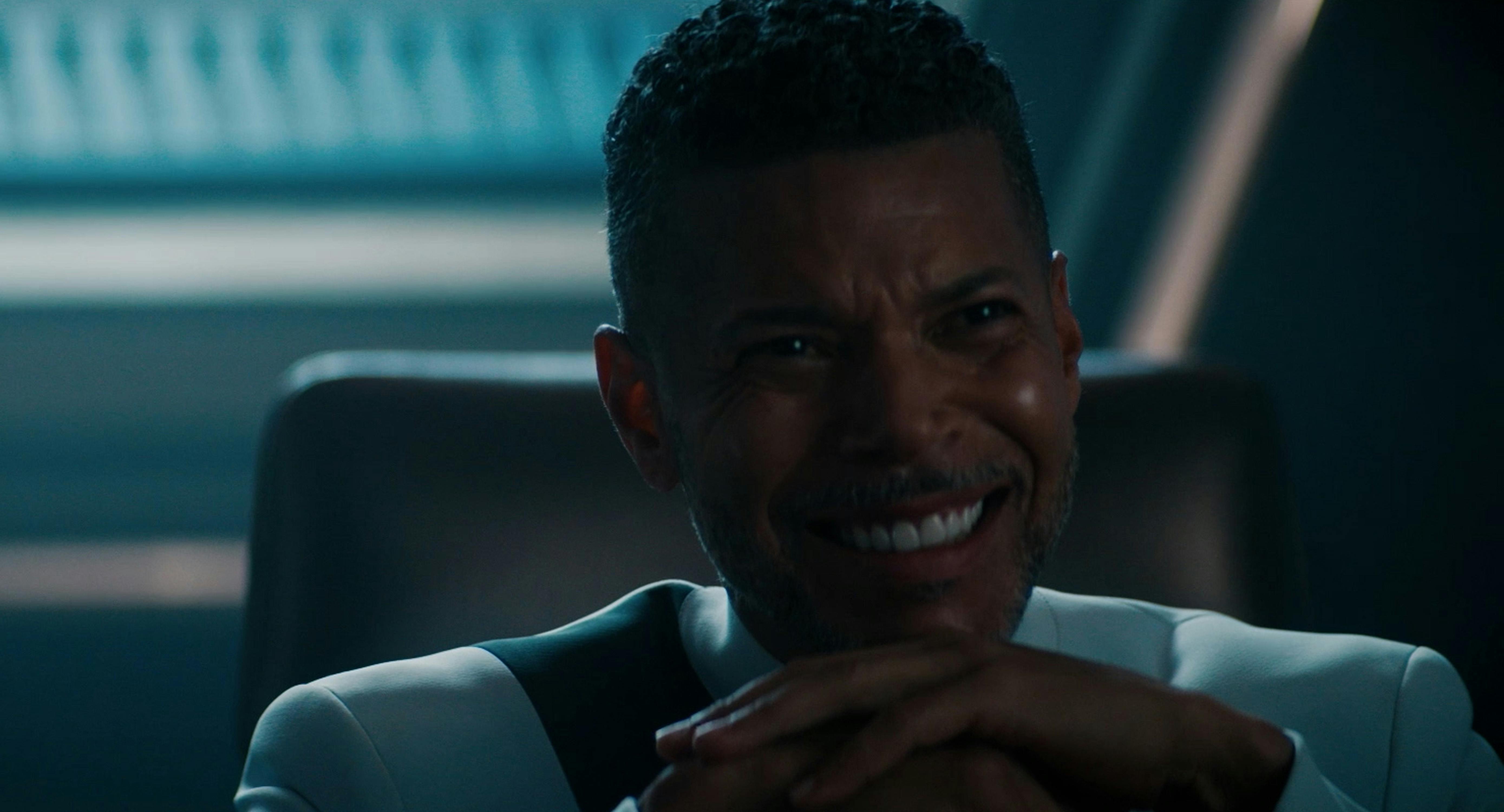In his office, Culber smiles as he rests his chin on his hands as he watches a holo of his abuela in 'Whistlespeak'