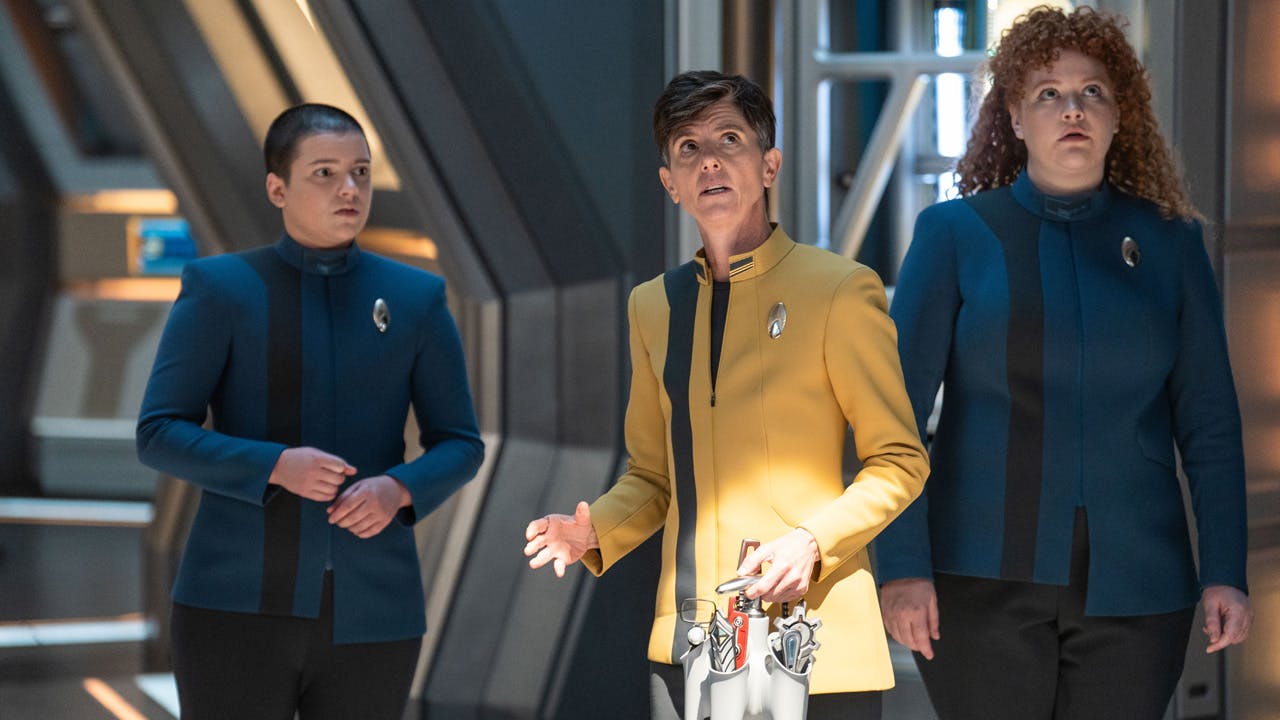 Adira, Reno, and Tilly stop in their tracks in the corridor of the Discovery as a Breen dreadnaught appears above in 'Erigah'